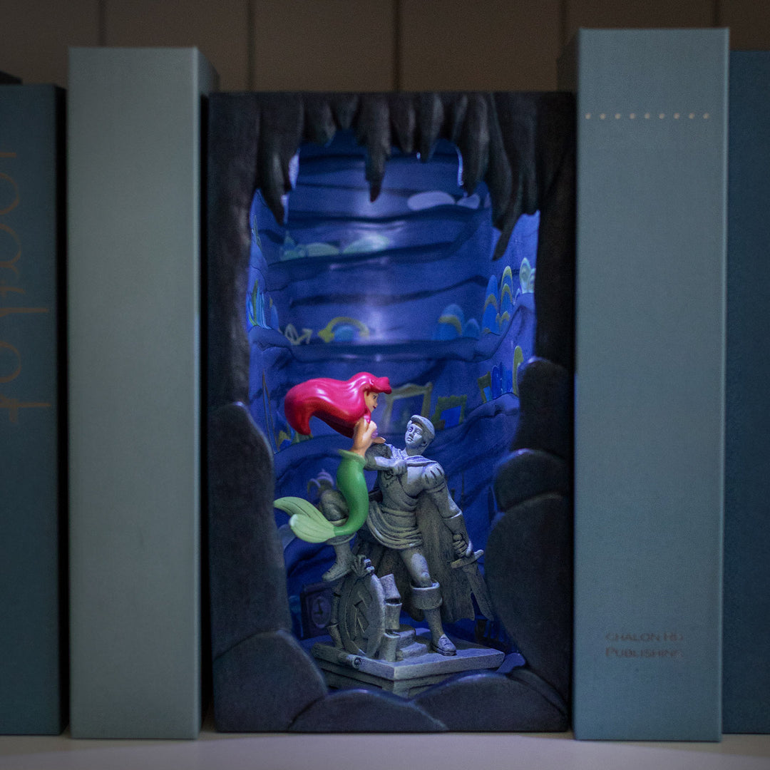 3D figurine of a blue dragon, red fairy, and gray knight inside a box
