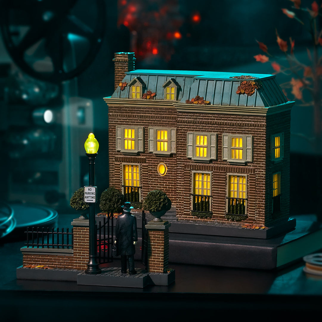 Model of a large house with lit windows on a dark background