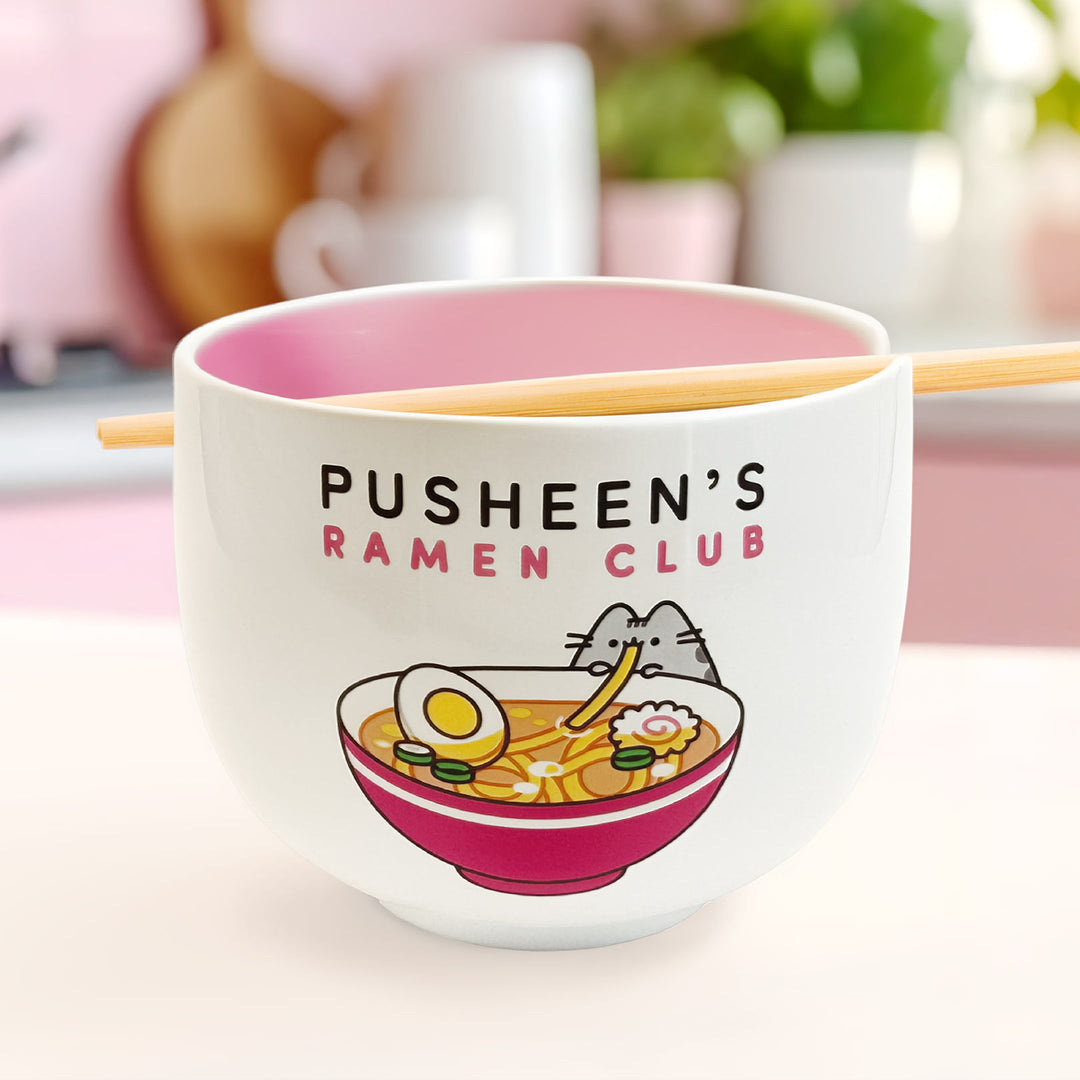 Ceramic ramen bowl with 'Pusheen's Ramen Club' text and illustration on a pink background.