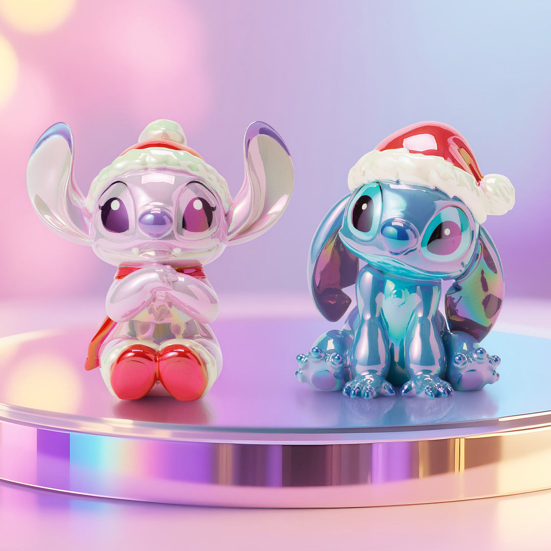 Two colorful Stitch figurines with Santa hats on a reflective surface with a gradient background.
