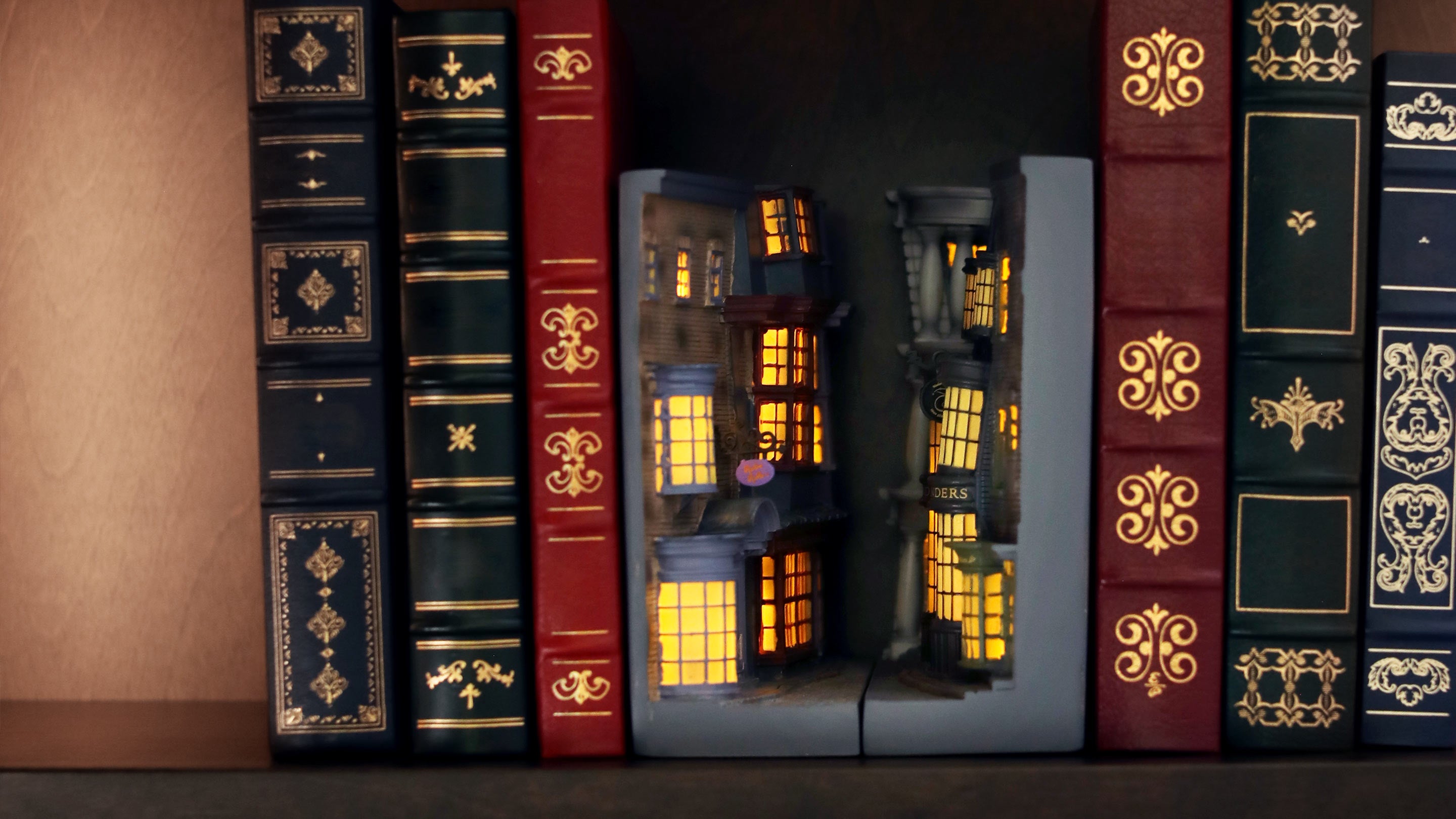 Decorative bookshelf with ornate books and a small model house inside